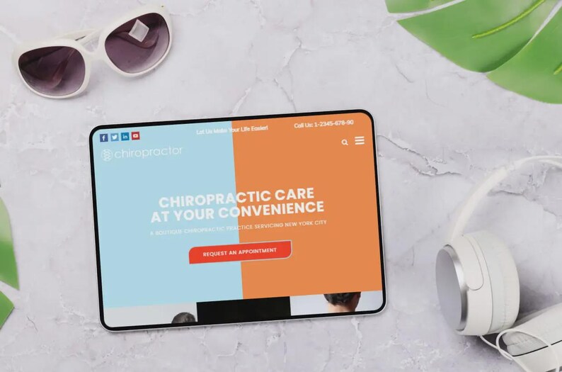 Puede incluir: Una tableta muestra un sitio web de quiropr&aacute;ctica con el texto "Chiropractic Care at Your Convenience". Gafas de sol blancas y auriculares sobre una superficie de m&aacute;rmol.