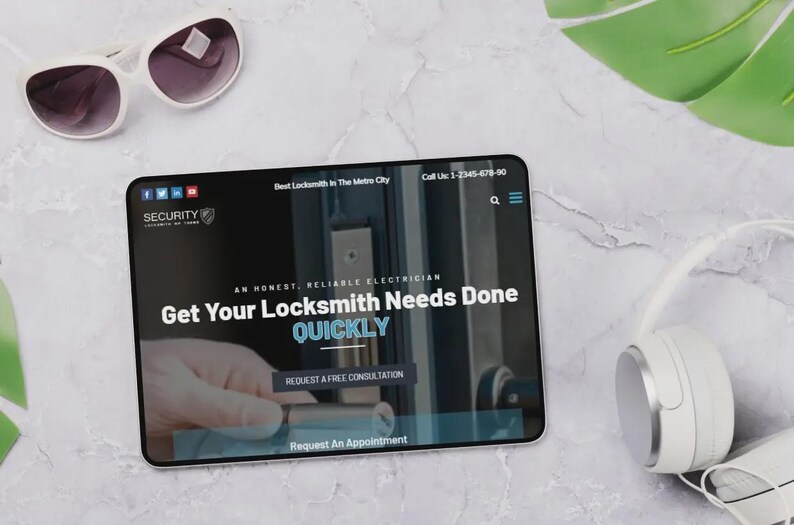 May include: A tablet displaying a locksmith service website, with the text "Get Your Locksmith Needs Done QUICKLY." White sunglasses and headphones are placed near the tablet. The website logo reads "SECURITY".