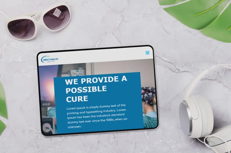Puede incluir: Una tableta que muestra un sitio web con el texto "WE PROVIDE A POSSIBLE CURE" y el logotipo "MEN'S HEALTH". Gafas de sol y auriculares blancos tambi&eacute;n son visibles en una superficie de m&aacute;rmol.