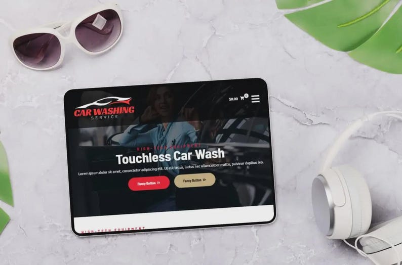 K&ouml;nnte beinhalten: Ein Tablet zeigt eine Website f&uuml;r einen Autowaschservice mit dem Text "Touchless Car Wash". Wei&szlig;e Sonnenbrille, Kopfh&ouml;rer und ein gr&uuml;nes Blatt liegen auf einer Marmoroberfl&auml;che.