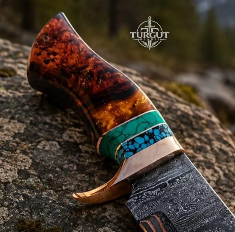 May include: A fixed-blade knife featuring a polished Damascus steel blade and a handle crafted from dark brown burl wood. The handle includes decorative bands of turquoise and blue stone inlays, accented by a metallic bolster with a curved guard.