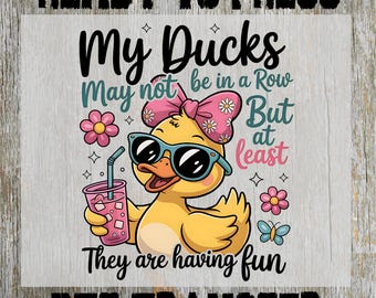 May include: A DTF transfer design featuring a cartoon duck wearing sunglasses and a bow, holding a drink. Text reads "My Ducks May not be in a Row But at least They are having fun". Includes flowers and a butterfly.