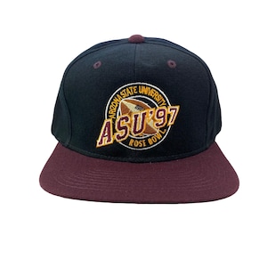 May include: A black and maroon baseball cap featuring the Arizona State University logo with a football and the text "ASU '97 Rose Bowl". The cap has a flat brim and a button on top.