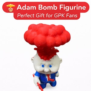 May include: A figurine of a cartoon character with a red explosion cloud above its head. The character has a white face, blue eyes, and is wearing a blue suit with a red tie. The text "Adam Bomb Figurine" is displayed above the figurine.