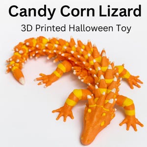Puede incluir: Un juguete de Halloween impreso en 3D con forma de lagarto, diseñado para parecerse a caramelos de maíz. El lagarto es naranja con rayas amarillas y puntas blancas. Incluye el texto "Candy Corn Lizard" y "3D Printed Halloween Toy".