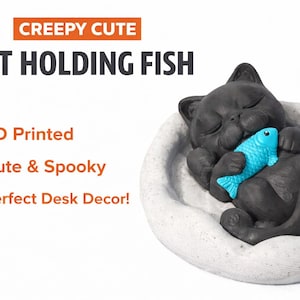 Puede incluir: Una figura de gato negro impresa en 3D sosteniendo un pez turquesa, descansando en una estructura blanca en forma de cama. El texto "CREEPY CUTE CAT HOLDING FISH" se muestra encima del gato. Una decoración de escritorio linda y espeluznante.