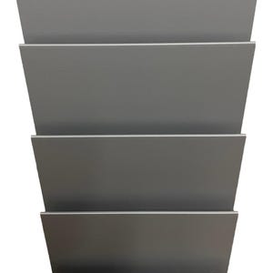 May include: A gray metal wall-mounted magazine rack with five horizontal shelves. The shelves are angled slightly upward, creating a tiered design. The rack is made of a smooth, solid material and is designed to hold magazines or other reading materials.