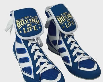 May include: Pair of blue and white boxing shoes with the text "NO BOXING NO LIFE" in gold lettering on the tongue. The shoes have white laces and a high-top design, suitable for boxing training and competition.