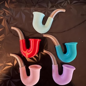 May include: An assortment of colorful tobacco pipes in shades of red, blue, teal, pink, and purple. Each pipe has a silver-colored stem. The pipes are arranged on a black surface.