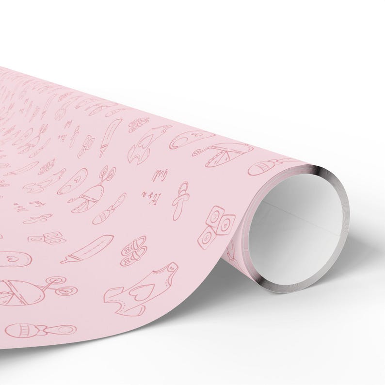 K&ouml;nnte beinhalten: Eine Rolle rosa Geschenkpapier mit einem sich wiederholenden Muster von Baby-Themen-Kritzeleien in dunklerem Rosa. Die Kritzeleien umfassen Schnuller, Babyschuhe und andere Baby-Artikel. Der Text "It's a girl" ist ebenfalls sichtbar.