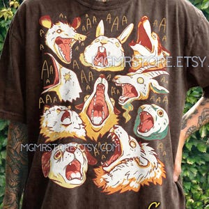May include: Brown t-shirt featuring a graphic of various animal heads with open mouths and the word "AAA" above them. The text "MGMRSTORE.ETSY.COM" and "MGMRSTORE" are also visible. The shirt is labeled "Espresso comfort colors."