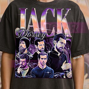 以下が含まれることがあります： ジャック・ドーシーのグラフィックが特徴の濃いグレーのTシャツ。「Jack Dorsey」という名前が大きく様式化された文字でデザインされ、ドーシーの複数の画像と紫とオレンジのグラデーションが含まれています。