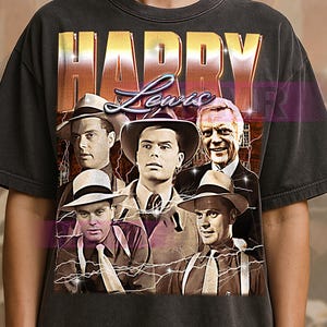 Puede incluir: Camiseta gris oscuro con un diseño vintage, con el nombre "HARRY Lewis" en letras desgastadas. La camiseta muestra un collage de imágenes en blanco y negro de hombres, con gráficos de rayos.