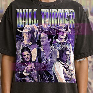 Puede incluir: Camiseta gris oscuro con un gráfico de Will Turner de la serie de películas Piratas del Caribe. El diseño incluye múltiples imágenes del personaje con el nombre "WILL TURNER" en una fuente estilizada. La camiseta tiene un aspecto vintage y desgastado.