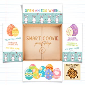 May include: An open cardboard box with Easter-themed decorations. The box features illustrations of Easter eggs, bunnies, and text that reads "OPEN AN EGG WHEN..." and "SMART COOKIE print shop". The box is decorated with colorful eggs.