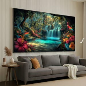 Op de afbeelding: Een groot ingelijst canvasdoek met een levendige tropische watervalscène. Het kunstwerk toont een turquoise zwembad, weelderig groen, kleurrijke bloemen en een papegaai. Het schilderij wordt boven een grijze bank in een woonkamer getoond.