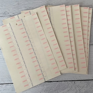 May include: A stack of vintage cream-colored paper tickets with red printed numbers and perforated edges. The tickets are arranged in a fan shape, with the numbers 29982, 29983, 29985, 29990, and 29991 visible.