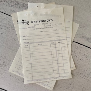 May include: A stack of vintage Sunoco Worthington's invoices. The invoices are printed on off-white paper with black text and lines. The text includes the company name, address, phone number, and fields for customer information and item details.