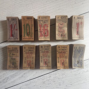 May include: A collection of vintage bus tickets, each with unique serial numbers and text. The tickets are rectangular, with a beige background and red and green text. Some tickets have the words "Omnibus Ticket" printed on them.