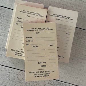 May include: A stack of vintage pharmacy memo pads. Each pad is cream-colored with printed lines for patient information, Rx number, and amount. The text "SAVE THIS MEMO FOR YOUR INSURANCE AND INCOME TAX RECORD" is printed at the top. The bottom of the pad reads "CLANTON'S DRUG STORE, Inc."
