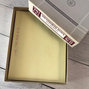 Może przedstawiać: Pudełko papieru Southworth Duo Manifold, rozmiar 21,6 x 27,9 cm, z napisem "COPY" na papierze. Pudełko jest jasnoszare z bordową etykietą. Papier w środku jest jasnożółty.