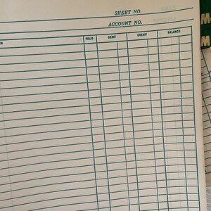 May include: A close-up of a ledger sheet with a grid of horizontal and vertical lines. The sheet is off-white with green lines and text at the top that reads "SHEET NO." and "ACCOUNT NO."