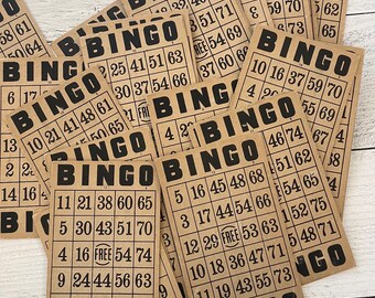 May include: A collection of vintage bingo cards. Each card is rectangular with a grid of numbers and the word "BINGO" at the top. The cards are printed in black ink on a tan background, giving them a retro aesthetic.