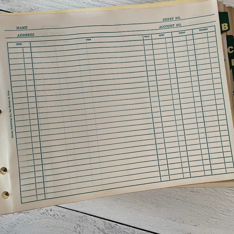 May include: Open ledger book pages with green ruled lines and columns for accounting. The top of the page includes fields for name, address, sheet number, and account number. The book is from Garser Publishing Co., Des Moines 13, Iowa.