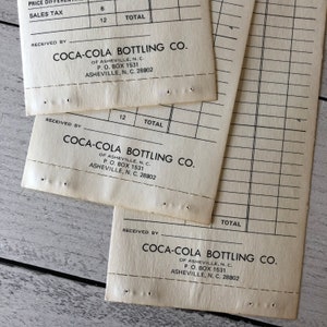 May include: Vintage Coca-Cola Bottling Co. receipts. The receipts are off-white with black text and grid lines. The text includes the company name, address, and the words "PRICE DIFF", "SALES TAX", and "TOTAL".