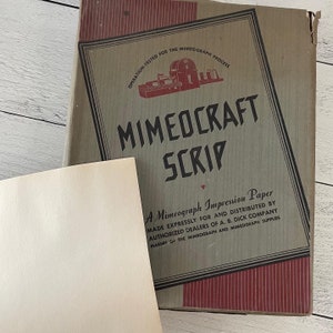May include: A vintage box of Mimeocraft Scrip paper with a sheet of paper in front. The box is tan with red accents and features the text "MIMEOCRAFT SCRIP" and "A Mimeograph Impression Paper".