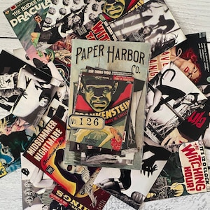 May include: A collection of vintage horror movie posters and ephemera, including titles like "Dracula" and "Frankenstein." The central piece is a packet labeled "Paper Harbor Co." with a "Frankenstein" cover. The color palette includes red, black, and white.