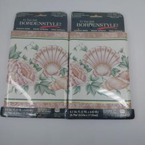 May include: Two rolls of Bordenstyle decorative border wallpaper. The wallpaper features a repeating pattern of pink seashells, flowers, and green leaves on a white background. The border is 6.83 inches high and 5 yards long.