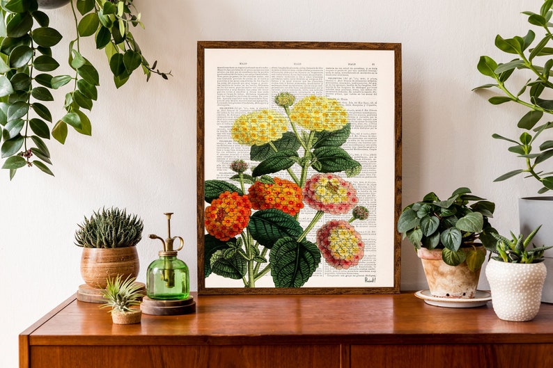 May include: A framed botanical print of a cluster of yellow, orange, and pink flowers with green leaves on a white background. The print is framed in a dark brown wood frame.