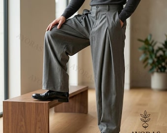 May include: Gray wide-leg trousers with pleats, paired with black leather shoes. The pants have a high waist and a relaxed fit. The image also shows a wooden bench and a dark gray long-sleeve shirt.