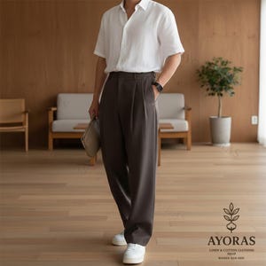 Mocha black wide leg pleated pants for men, relaxed drape slacks styled with sneakers in minimalist room