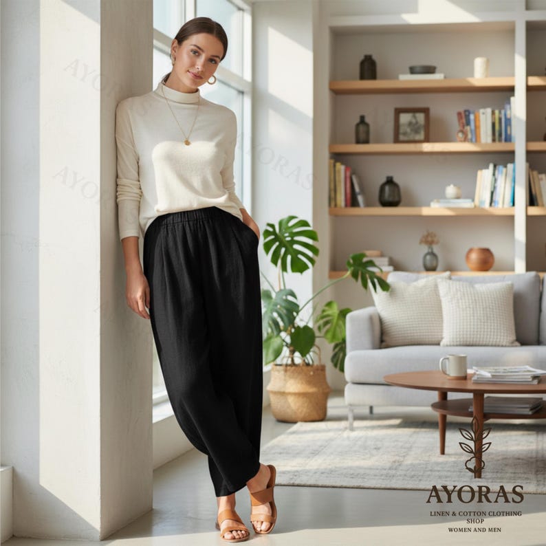 Puede incluir: Una mujer con un jersey de cuello alto color crema y pantalones de lino negros. Los pantalones tienen un corte holgado con cintura el&aacute;stica. La imagen est&aacute; tomada en interiores, con un fondo neutro y un logotipo de "AYORAS LINEN & COTTON CLOTHING SHOP WOMEN AND MEN".