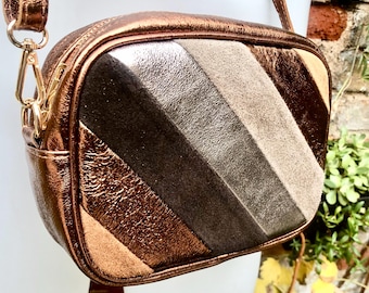 銅製の小さなレザーバッグ。本革のクロスボディ/ショルダーバッグ。メタリックな輝きのレザーバッグ。調節可能なストラップとジッパー。銅製の財布