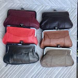 Puede incluir: Seis monederos de cuero en varios colores: burdeos, negro, coral, marrón, negro y topo. Cada monedero tiene un cierre de metal y un diseño cosido en la parte delantera.