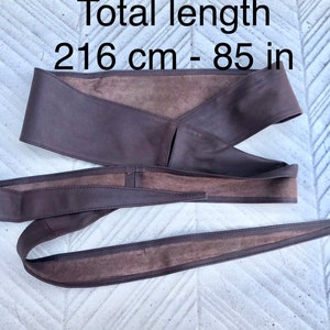 Op de afbeelding: Een bruine leren riem met een totale lengte van 216 cm of 85 inch.