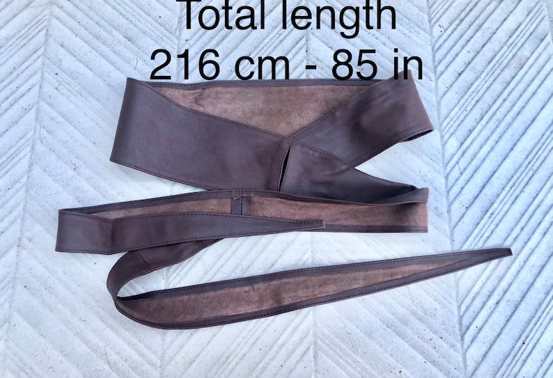 Op de afbeelding: Een bruine leren riem met een totale lengte van 216 cm of 85 inch.