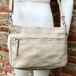 Beige Ledertasche. Weiche Umhängetasche aus echtem Leder mit Quaste. Beige Umhängetasche, Beige Geldbörse mit Reißverschluss und verstellbarem Riemen