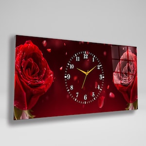 May include: Rectangular wall clock featuring a red rose design. The clock face is black with white numbers and gold hands. Two large red roses are on either side of the clock face, with falling petals.