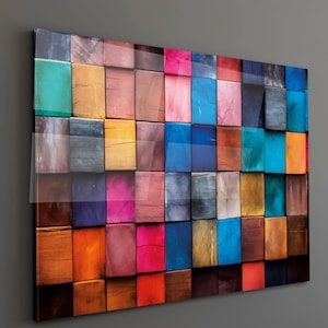 May include: A colourful wall art piece featuring a mosaic of wooden blocks in various shades. The blocks are arranged in a grid pattern, with colours ranging from vibrant reds and blues to earthy browns and greens. The artwork has a glossy finish.