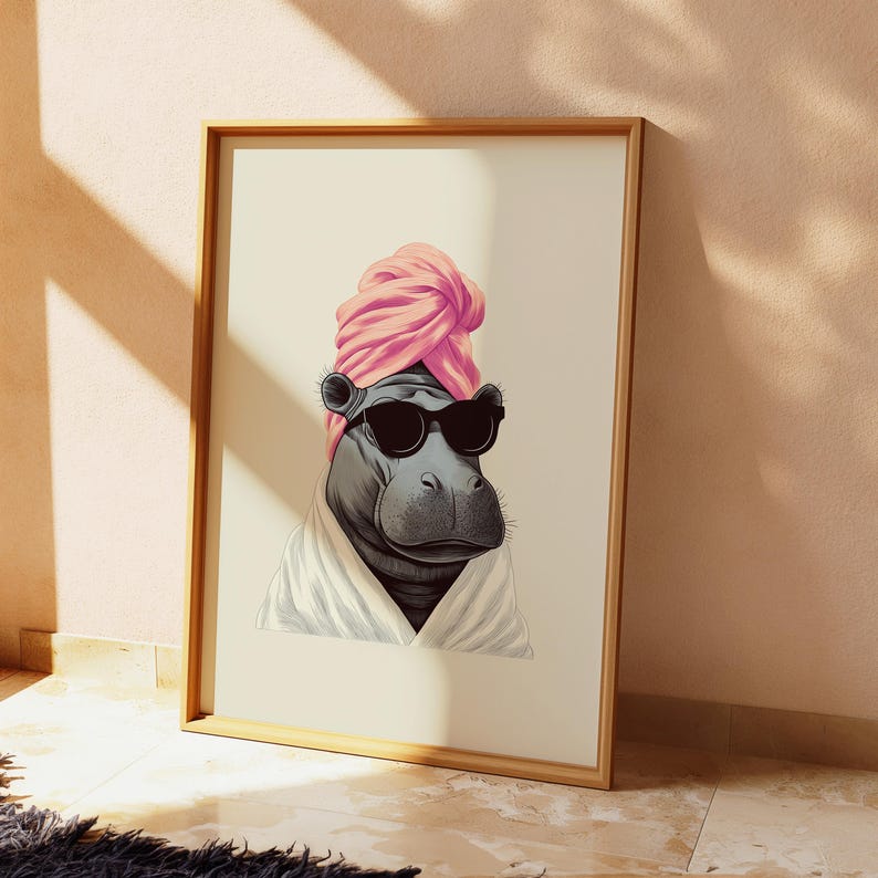 May include: A framed art print featuring a stylized hippo wearing sunglasses, a pink turban, and a white robe. The hippo is depicted in a relaxed pose, suggesting a spa or relaxation theme. The frame is made of wood.
