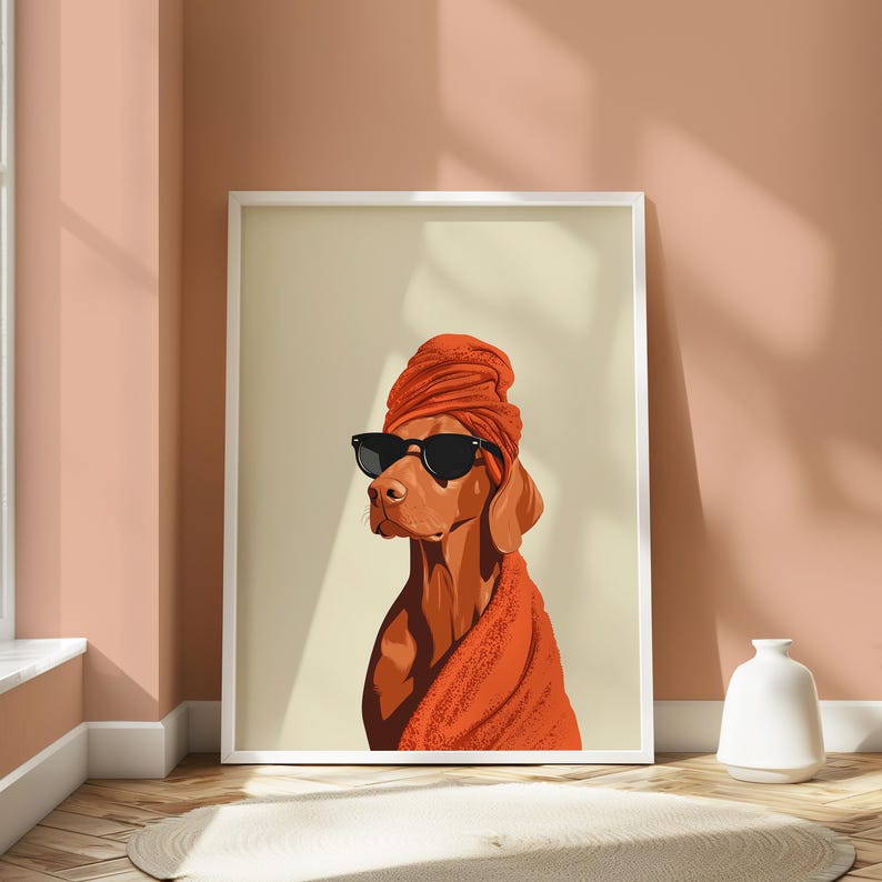 May include: A framed art print of a dog wearing sunglasses and a turban. The dog is rendered in shades of brown and orange, with black sunglasses. The background is a neutral beige, and the frame is white.