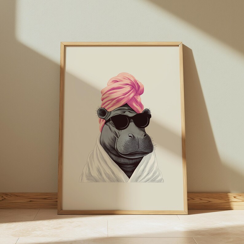 May include: A framed print featuring a hippopotamus wearing sunglasses, a pink turban, and a white robe. The artwork has a whimsical, spa-day theme, with the hippo's relaxed expression and attire. The image is set against a neutral background.