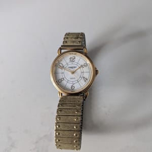 ゴールドトーンのヴィンテージコンスタントレディース腕時計。伸縮性のあるストラップ。