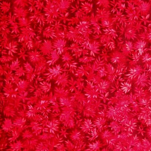 May include: A vibrant red fabric featuring a dense, repeating pattern of small, delicate leaves and foliage. The design uses varying shades of red to create depth and texture across the surface, resulting in a consistent, monochromatic botanical print.
