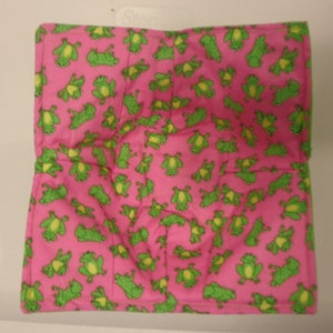 May include: Pink fabric square with a repeating pattern of green frogs.