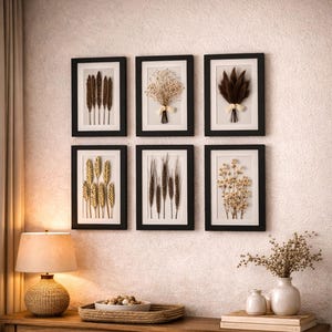May include: Six framed botanical prints with black frames are displayed on a textured wall. The prints feature dried plants and flowers. A wooden console table below holds a lamp, decorative tray, and woven baskets, creating a warm, inviting atmosphere.